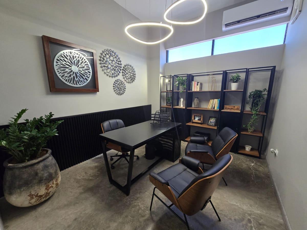 Oficina de dirección de Smarthink con escritorio, sillones y librero