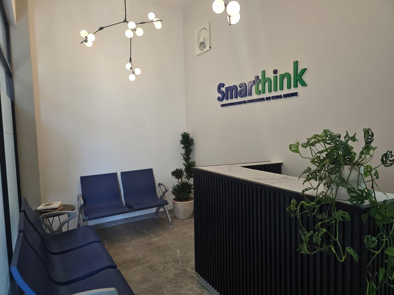 Recepción de Smarthink con sala de espera, logotipo en pared y mostrador